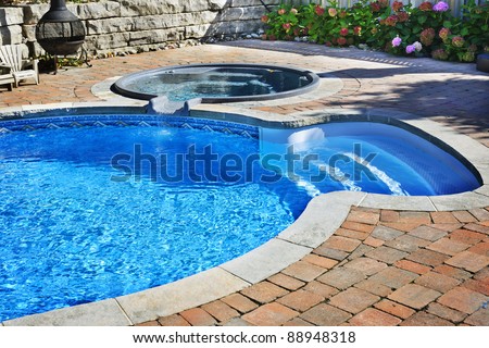 Outdoor in ground residential swimming pool in backyard with hot tub Royalty-Free Stock Photo #88948318