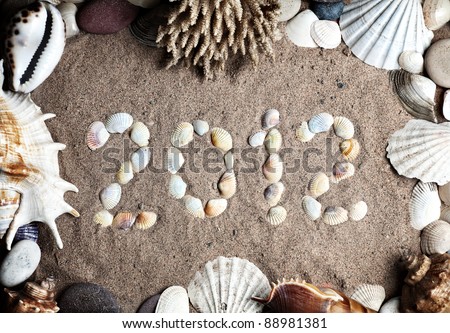 2012 new year message on the sand and seashells, coral and stones around it as a frame