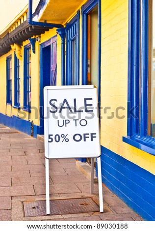 Sale sign outside a vibrant row of shops in England
