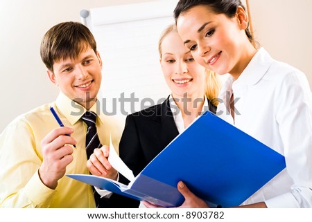 Portrait of successful business people looking at document in the office