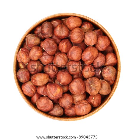 peeled hazelnuts in a wooden bowl, isolated, white background