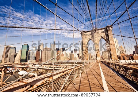 New York City Brooklyn Bridge in Manhattan closeup with skyscrapers and city skyline over Hudson River.
