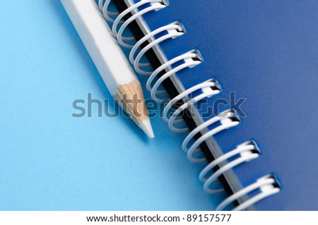 White pencil and spiral of notebook - macro
