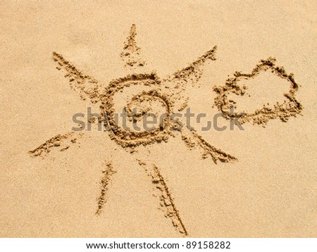 simple sun drawing in the sand on the beach