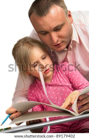 Sweet family reading a book at the table