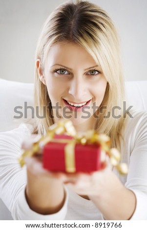 woman holding present out, present is not in focus