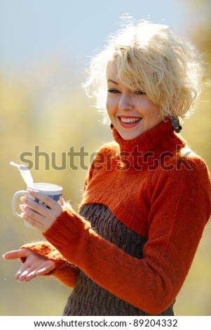  young woman holding cup of tea outdoor