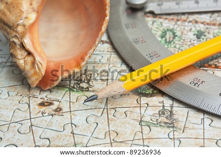 pencil and a seashell on the map