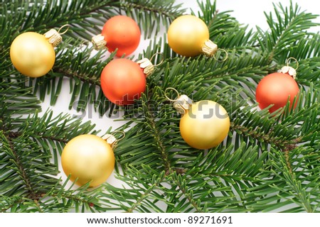 Christmas bulbs on green spruce decorations - isolated on white