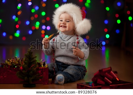 funny baby in Santa Claus hat on bright festive background