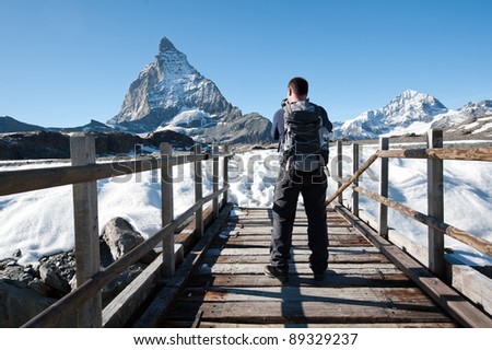 photographer on Glacier trail taking picture of Matterhorn, Switzerland