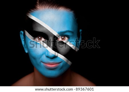 Portrait of a woman with the flag of the Botswana painted on her face.