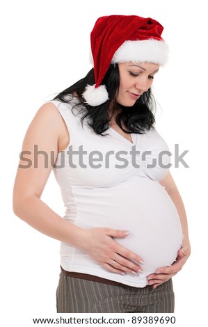 Portrait of a pregnant woman in santa hat over white background. Third trimester.