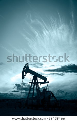 Oil and gas industry. Silhouette oil pump on a sunset sky background. Toned.