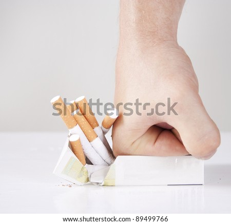 Man's hand crushing cigarettes Royalty-Free Stock Photo #89499766