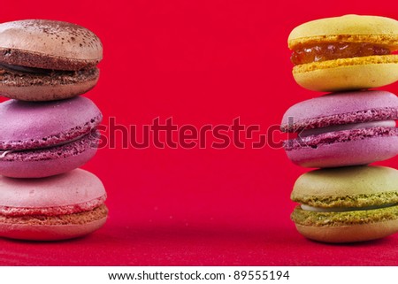 Frame of colorful  macaroons , card  on a red  background