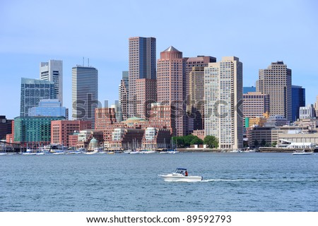 Boston downtown city skyline over sea with urban skyscrapers in the morning with cloudy sky and boat.