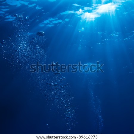 abstract underwater scene sunrays and air bubbles in deep blue sea Royalty-Free Stock Photo #89616973