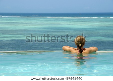 Picture of a woman in swimming-pool watching ocean