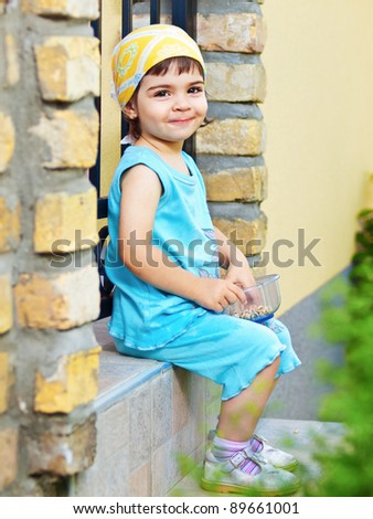 Adorable little girl eating snack outdoors portrait
