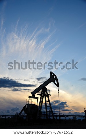 Oil and gas industry. Silhouette oil pump on a sunset sky background.