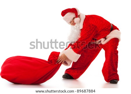 Funny Santa Clause pulling a heavy sack with gifts. Isolated on white.