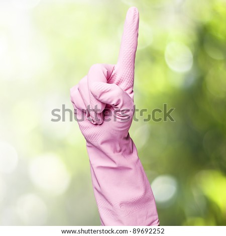 pink cleaning gloves pointing up against a plants background
