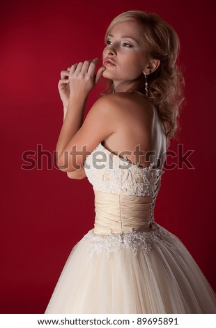 Funny bride in white bridal dress on red background. Studio shot, series of photos