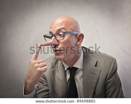 Lying businessman observing his long nose Royalty-Free Stock Photo #89698885
