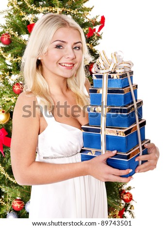 Girl in santa hat holding stack  gift box by christmas tree.. Isolated.