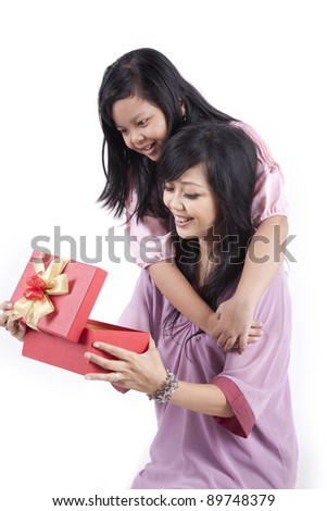 Happy family of mother and daughter opening a gift box