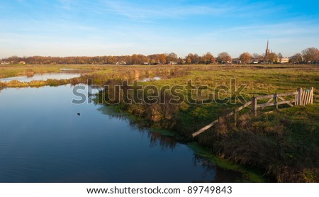 Autumnal view at the small Dutch river Mark and the outskirts of the village of Ulvenhout