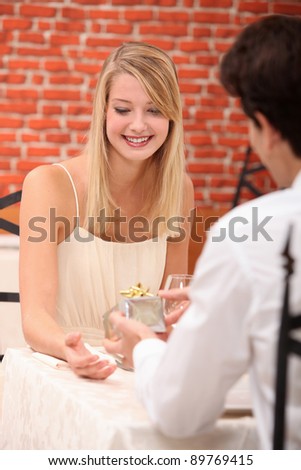Young woman receiving a present in a restaurant