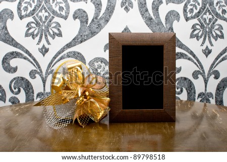Wooden photo frame and silver present box on table