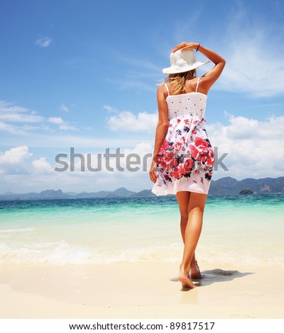 Young woman walking on a warm beach