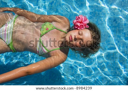 young woman floating in the swimming pool (spa resort)