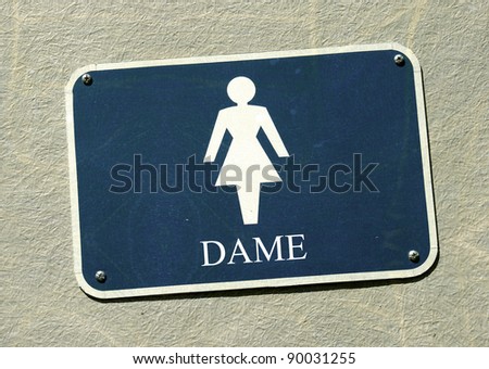 aged and worn vintage photo of sexist dame restroom sign