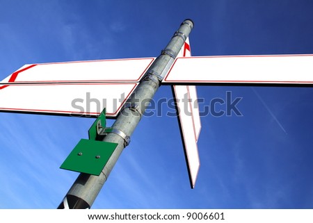 blank white direction boards with blue sky in the background