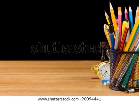 basket holder and school supplies isolated on black background