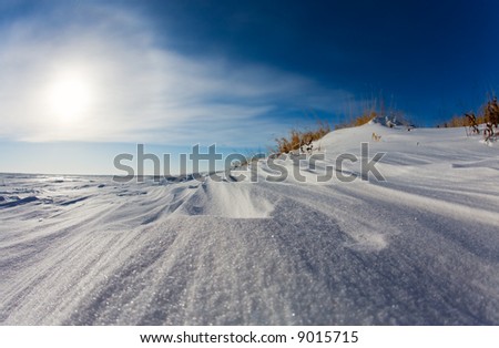 Wind swept snow on a frozen lake shore