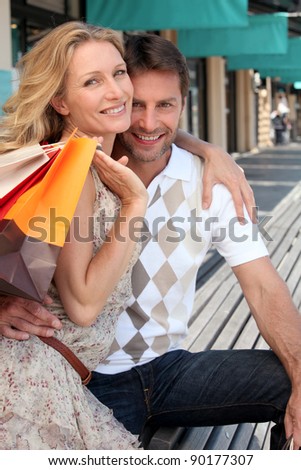 Couple with shopping bags outside boutiques