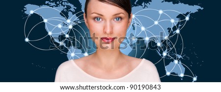 Portrait of young pretty woman looking at camera and standing in front of world map with glowing connection lines and server location points. Global Internet communications technology