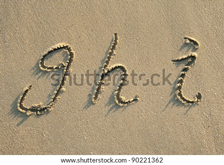 alphabet letters handwritten in sand on beach Royalty-Free Stock Photo #90221362