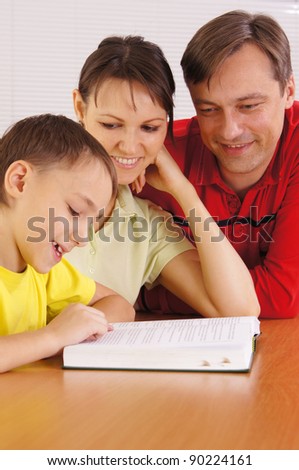 portrait of a cute family reading at table