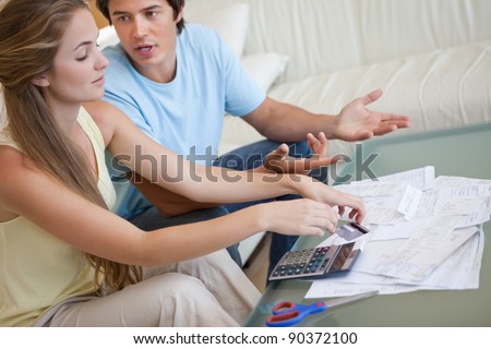 Couple having an argument about their bills in their living room Royalty-Free Stock Photo #90372100