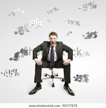 Young businessman shouting and sitting on a chair under falling percents signs. Discount concept depicting percentage symbols falling on man. On a gray background