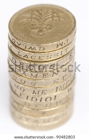 Stack of one pound coins showing latin words on edges.