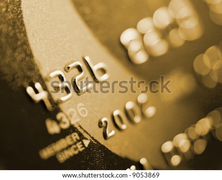 Close-up of silver digits on a credit card.  Very shallow depth of field, focus on number 2.  You can see the texture of the card in the in-focus areas.