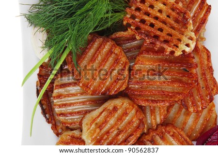 potato chips served on white plate with small pickled eggplants isolated over white background