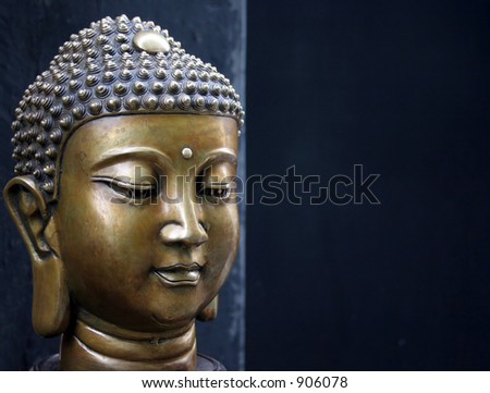 Bronze Buddha head on a black background - copy space